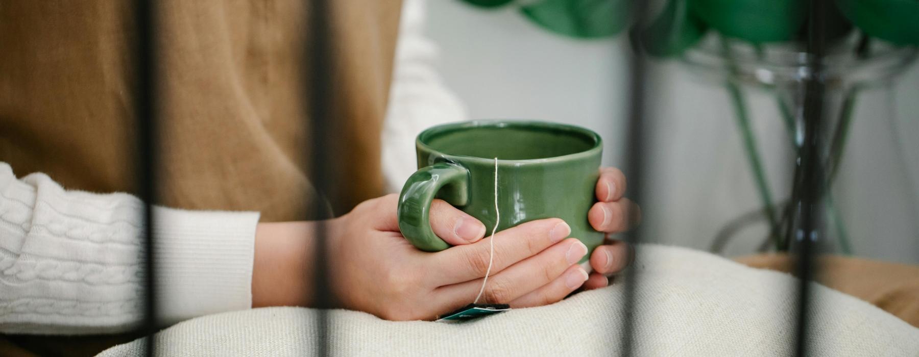 a person holding a green cup
